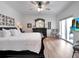 Spacious main bedroom featuring a dark wood furniture set, a ceiling fan, and sliding door access to a balcony at 701 N Atlantic Ave # 202, New Smyrna Beach, FL 32169