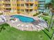 Exterior view of a pool deck with lounge chairs and a grassy area at 701 N Atlantic Ave # 202, New Smyrna Beach, FL 32169