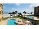 Resort-style pool area with palm trees, lounge chairs, and ocean view, creating a serene and luxurious retreat at 701 N Atlantic Ave # 202, New Smyrna Beach, FL 32169