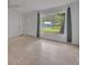 Living room with tile floors, large window, and view of the front yard at 798 E 11Th Ave, New Smyrna Beach, FL 32169