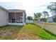 The backyard features a screened lanai and well-maintained lawn near a block fence at 1277 Harms Way, Port Orange, FL 32129