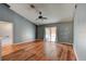 Bright living room with wood floors, gray walls, and a ceiling fan at 1277 Harms Way, Port Orange, FL 32129