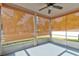 Enclosed patio featuring a ceiling fan and natural light filtering through woven shades at 1277 Harms Way, Port Orange, FL 32129