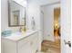 Bathroom featuring a single vanity with light marble countertops, and a doorway leading to an adjacent room at 452 Lime Ave, Daytona Beach, FL 32124