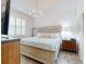 Bright bedroom with light hardwood floors, decorated headboard, white shutters, and decorative chandelier at 452 Lime Ave, Daytona Beach, FL 32124