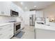 Modern kitchen with white cabinetry, stainless appliances, light countertops and faucet at 452 Lime Ave, Daytona Beach, FL 32124