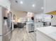 Open-concept kitchen features stainless appliances, island with counter seating, and seamless flow to living area at 452 Lime Ave, Daytona Beach, FL 32124