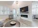 Bright living room with modern fireplace, wood floors, and stylish decor, complemented by a view into the dining area at 452 Lime Ave, Daytona Beach, FL 32124