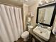Cozy bathroom featuring a shower with a curtain, a framed mirror, and a rustic single sink at 501 N Causeway # 2050, New Smyrna Beach, FL 32169