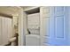 Stackable washer and dryer located in a closet, adjacent to a partially-viewed bathroom at 501 N Causeway # 2050, New Smyrna Beach, FL 32169
