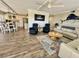 Open-concept living space features wood-look floors, comfortable furniture, and ocean-themed decor at 501 N Causeway # 2050, New Smyrna Beach, FL 32169