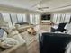 Bright living room with large windows, comfortable seating, wood-look floors, and beachy decor at 501 N Causeway # 2050, New Smyrna Beach, FL 32169