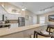 Spacious kitchen with stainless steel appliances and a breakfast bar, open to the dining area at 682 Middlebury Loop, New Smyrna Beach, FL 32168