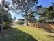 A wide shot of the backyard of a house and the foliage, featuring a fenced perimeter at 115 E Turgot Ave, Edgewater, FL 32132