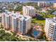 Aerial view showcasing condos with red roofs, manicured landscaping, and a sparkling pool area at 253 Minorca Beach Way # 205, New Smyrna Beach, FL 32169