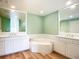 A bright bathroom features a corner tub, dual sinks, and white cabinets at 253 Minorca Beach Way # 205, New Smyrna Beach, FL 32169