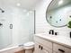 This bathroom boasts a modern glass shower, sleek fixtures, and a stylish round mirror at 253 Minorca Beach Way # 205, New Smyrna Beach, FL 32169