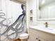 Bright bathroom featuring shiplap walls, modern vanity and mirror, and octopus shower curtain at 253 Minorca Beach Way # 205, New Smyrna Beach, FL 32169