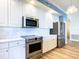 Modern kitchen boasts stainless steel appliances, white cabinetry, ample counter space, and stylish backsplash at 253 Minorca Beach Way # 205, New Smyrna Beach, FL 32169