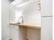 A bright laundry area features a sink, white cabinet, and scallop tile backsplash at 253 Minorca Beach Way # 205, New Smyrna Beach, FL 32169