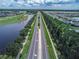 Aerial view of the neighborhood with a lake on the left and the road on the right at 3325 Pintello Ave, New Smyrna Beach, FL 32168