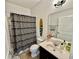 Bathroom with a bathtub, toilet, sink, and decorative surfboard, featuring a stylish design at 3325 Pintello Ave, New Smyrna Beach, FL 32168