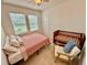 Bedroom with a bed and crib, featuring natural light and tiled floors, providing a comfortable living space at 3325 Pintello Ave, New Smyrna Beach, FL 32168