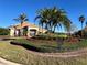 Beautiful clubhouse entrance framed by manicured landscaping, flowers, and towering palm trees at 3325 Pintello Ave, New Smyrna Beach, FL 32168