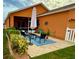 Back patio with a table, chairs, and umbrella, featuring a cozy and inviting outdoor living space at 3325 Pintello Ave, New Smyrna Beach, FL 32168