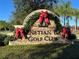 Stone sign for Venetian Bay Golf Club beautifully decorated with Christmas garlands and bows at 3325 Pintello Ave, New Smyrna Beach, FL 32168