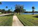 Scenic view of the tree-lined sidewalk next to a tranquil lake, perfect for outdoor enjoyment at 3325 Pintello Ave, New Smyrna Beach, FL 32168
