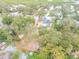 Aerial view of a property with a house, pool, large backyard, mature trees, and a wooden perimeter fence at 532 Faulkner St, New Smyrna Beach, FL 32168