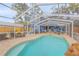 Spacious backyard with screened pool and patio, offering a picturesque view of the charming blue house at 532 Faulkner St, New Smyrna Beach, FL 32168