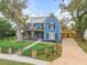 Charming two-story blue home with inviting front porch and balcony, surrounded by a well-manicured lawn at 532 Faulkner St, New Smyrna Beach, FL 32168