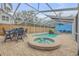 Inviting pool and spa featuring a screened enclosure, outdoor seating, and a tropical mural backdrop at 532 Faulkner St, New Smyrna Beach, FL 32168