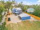 Aerial view of a blue two-story home with a screened-in pool, detached garage, fenced yard, and paved driveway at 532 Faulkner St, New Smyrna Beach, FL 32168