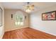 Bedroom with wood floors, ceiling fan, neutral colored walls, and a window for natural light at 6793 Calistoga Cir, Port Orange, FL 32128