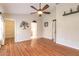 Bedroom with wood floors, ceiling fan, neutral colored walls, and three door frames visible at 6793 Calistoga Cir, Port Orange, FL 32128