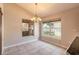 Bright dining area with tiled floors, modern chandelier, and windows overlooking the backyard at 6793 Calistoga Cir, Port Orange, FL 32128