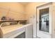 Functional laundry room with washer, dryer, storage shelves, and convenient access to the outdoors at 6793 Calistoga Cir, Port Orange, FL 32128