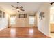Living room featuring wood floors, ceiling fan, neutral colored walls, and two windows at 6793 Calistoga Cir, Port Orange, FL 32128