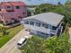Aerial view of a 2-story home, exterior deck, 1-car garage, off-street parking and lush landscaping at 824 Garfish Ave, New Smyrna Beach, FL 32169
