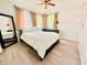 Cozy bedroom with wood-look flooring, large windows and a full-length mirror reflecting a queen sized bed at 824 Garfish Ave, New Smyrna Beach, FL 32169