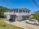 Two-story home with light-blue siding, a white garage door, and a large driveway at 824 Garfish Ave, New Smyrna Beach, FL 32169