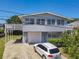 A charming home with a white garage door and a well-maintained lawn and driveway at 824 Garfish Ave, New Smyrna Beach, FL 32169
