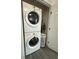 Conveniently stacked washer and dryer unit, optimizing space for laundry needs with gray flooring at 824 Garfish Ave, New Smyrna Beach, FL 32169