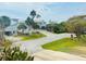 A street view of the neighborhood showcasing well-maintained lawns and beautiful homes under a bright sky at 824 Garfish Ave, New Smyrna Beach, FL 32169