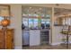 Wet bar with granite countertop, mini fridge, wine cooler, and mirrored backsplash at 4621 S Atlantic Ave # 7101, Ponce Inlet, FL 32127