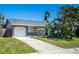 Ranch style home with gray stone accents, a paved driveway and well-maintained landscaping at 4623 Saxon Dr, New Smyrna Beach, FL 32169