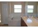 Bright bathroom featuring a large tub, white tiling, and vanity with a marble-style countertop at 537 Coral Trace Blvd, Edgewater, FL 32132